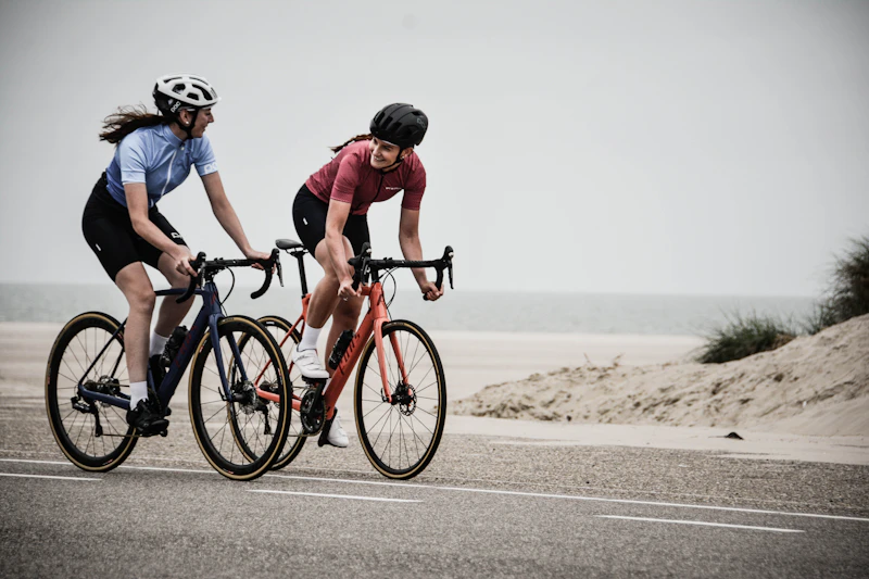 Pareja en bicicleta de carretera junto a la playa