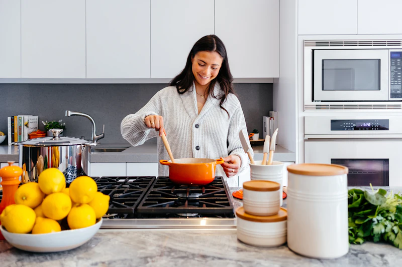 Mujer sonriente cocinando en una cocina luminosa