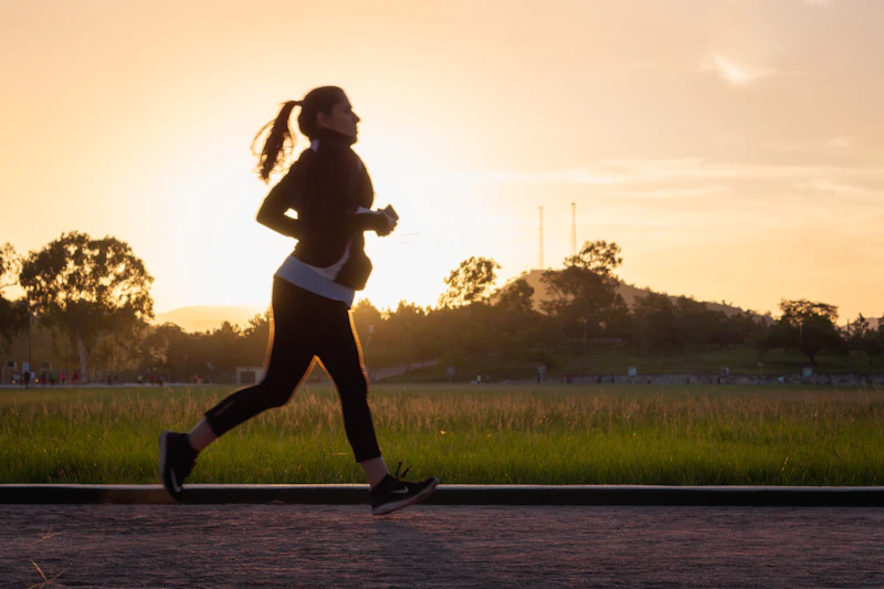 Mujer corriendo al atardecer por un camino