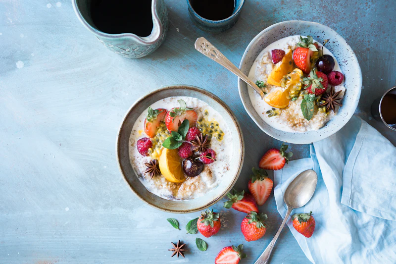 Dos cuencos de avena con fruta fresca para desayunar