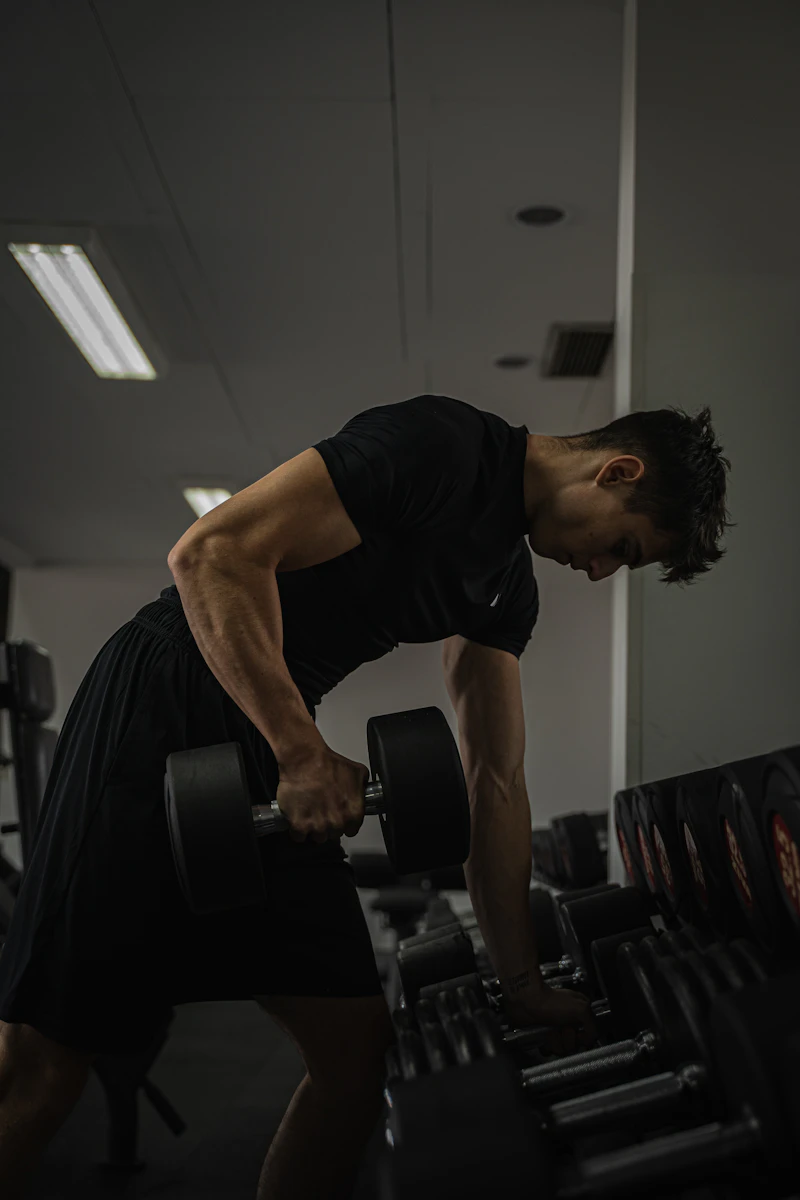 Hombre entrenando con mancuerna en un gimnasio