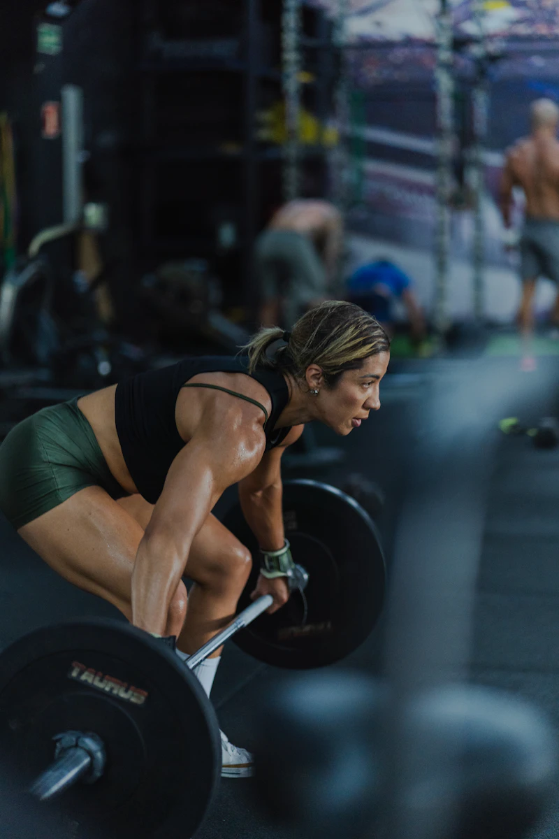Mujer levantando una barra pesada en el gimnasio