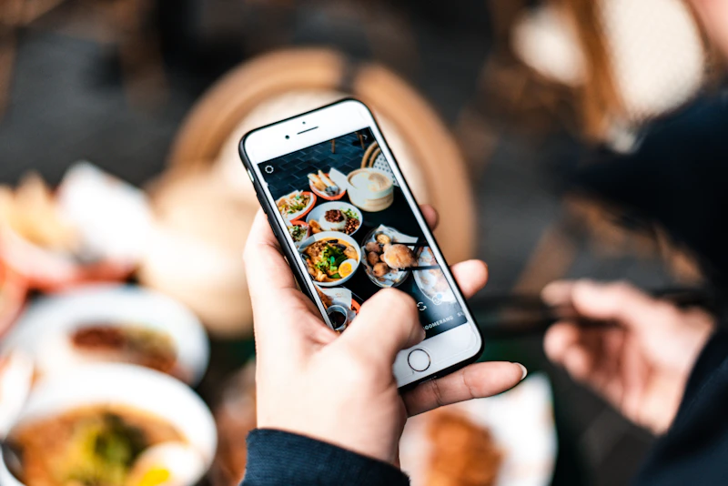 Móvil en la mano mostrando la foto de un plato